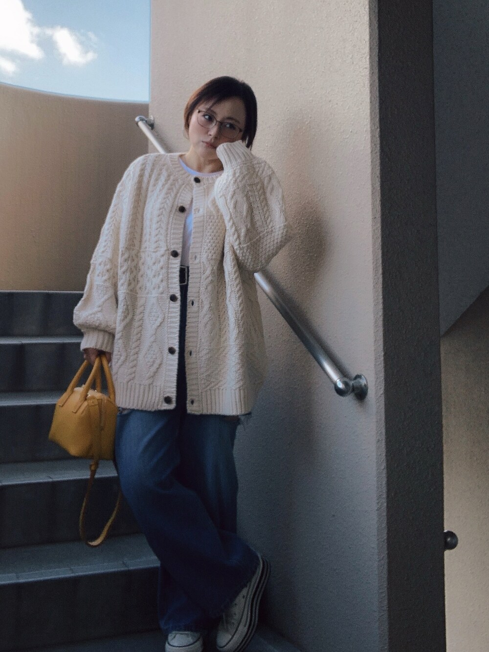 ホワイト系のカーディガン/ボレロ、ホワイト系のTシャツ/カットソー、ブルー系のデニムパンツを着用したレディースの冬コーディネートの3枚目の写真