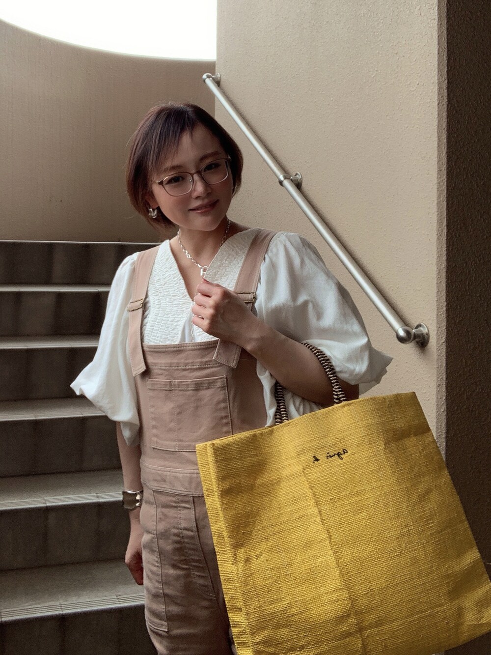 ホワイト系のシャツ/ブラウス、ベージュ系のサロペット/オーバーオール、ホワイト系のサンダルを着用したレディースの春コーディネートの3枚目の写真