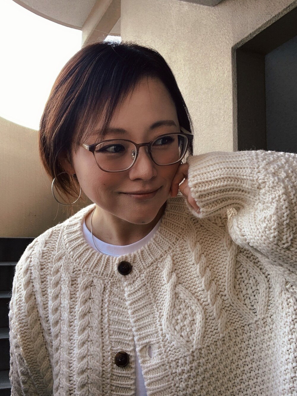 ホワイト系のカーディガン/ボレロ、ホワイト系のTシャツ/カットソー、ブルー系のデニムパンツを着用したレディースの冬コーディネートの2枚目の写真