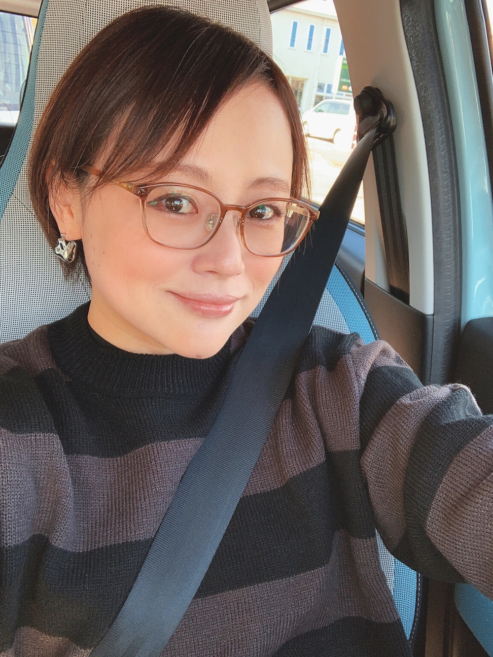 ブラック系のニット/セーター、ブルー系のサロペット/オーバーオール、ブラック系のブーツを着用したレディースの秋コーディネートの4枚目の写真