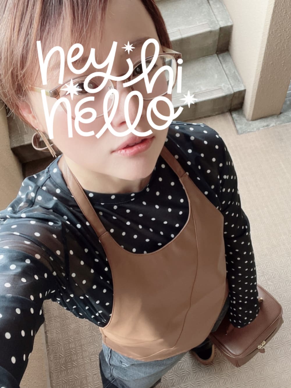 ブラック系のデニムパンツ、ブラック系のスニーカー、ブラウン系のベストを着用したレディースの秋コーディネートの2枚目の写真