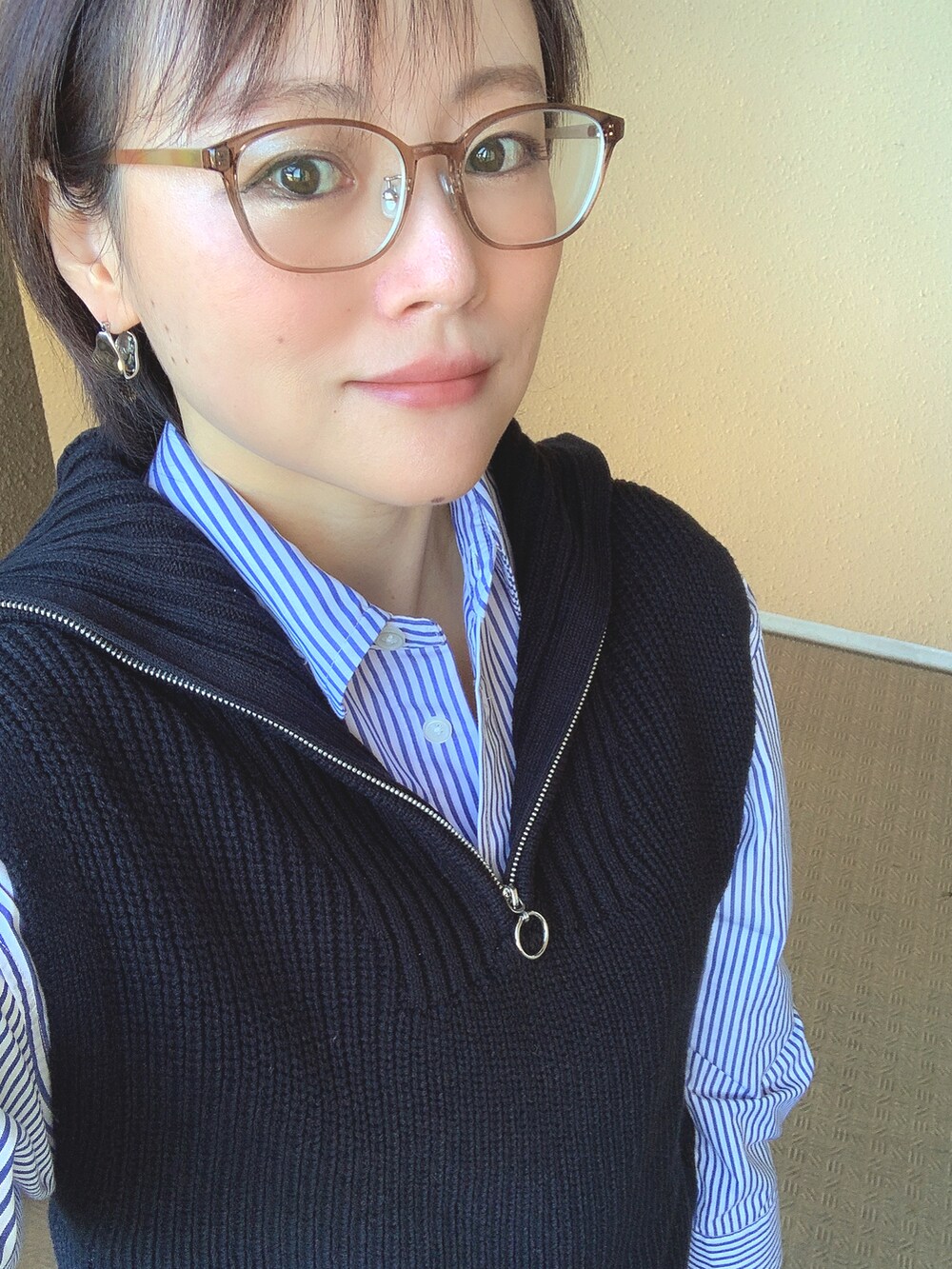 ブラック系のベスト、ブルー系のシャツ/ブラウス、ブラック系のデニムパンツを着用したレディースの冬コーディネートの2枚目の写真