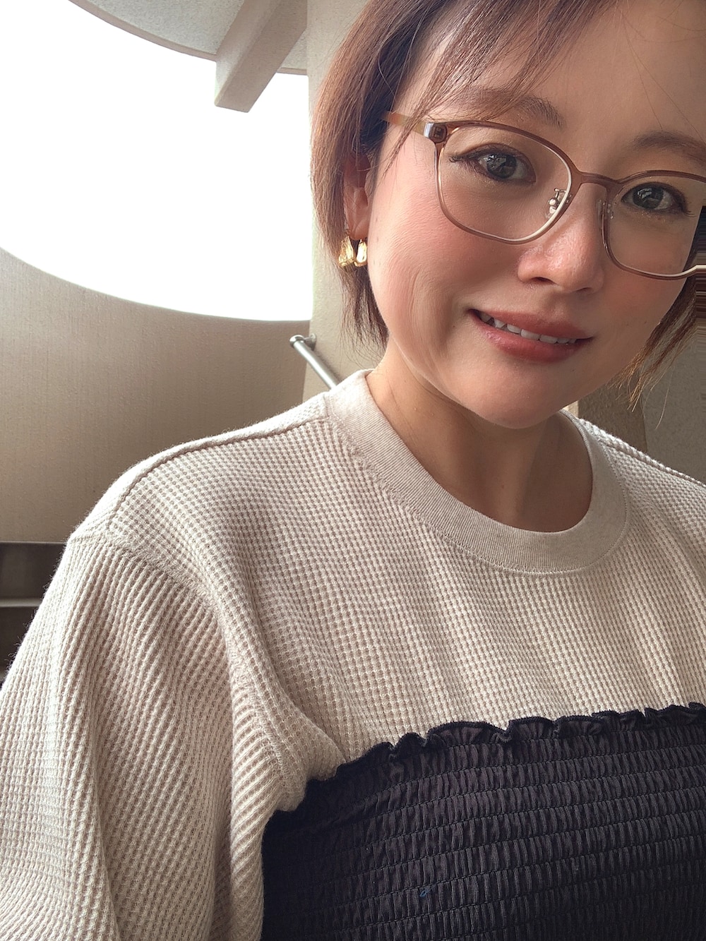 ブラック系のチューブトップ、ベージュ系のTシャツ/カットソー、ブルー系のデニムパンツを着用したレディースの春コーディネートの3枚目の写真