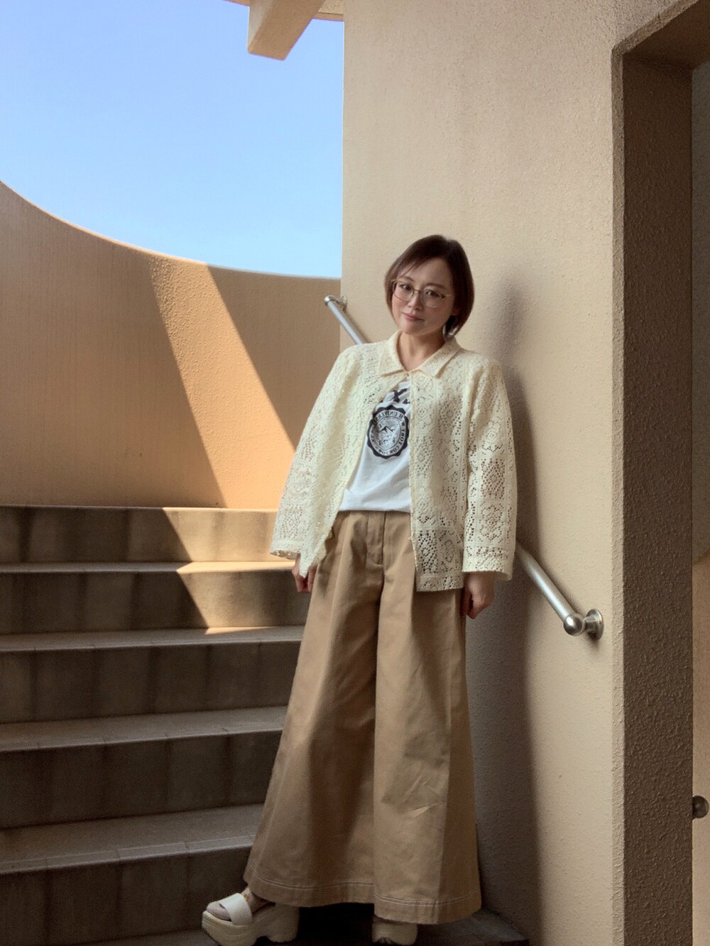 ホワイト系のTシャツ/カットソー、ホワイト系のシャツ/ブラウス、ベージュ系のチノパンツを着用したレディースの春コーディネートの2枚目の写真