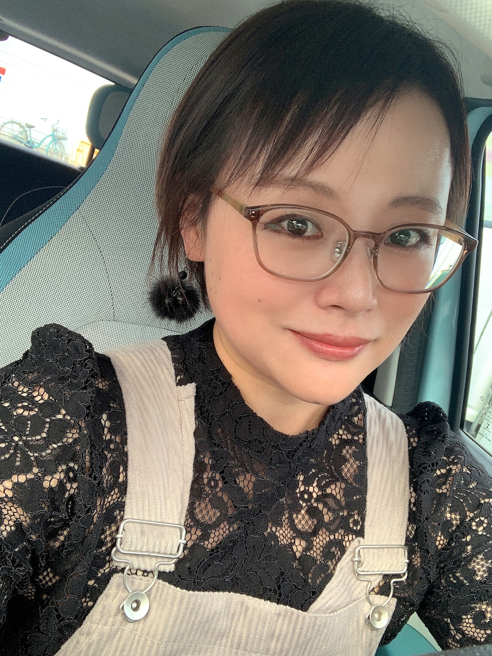 グレー系のジャンパースカート、ブラック系のシャツ/ブラウス、ブラック系のサンダルを着用したレディースの秋コーディネートの2枚目の写真