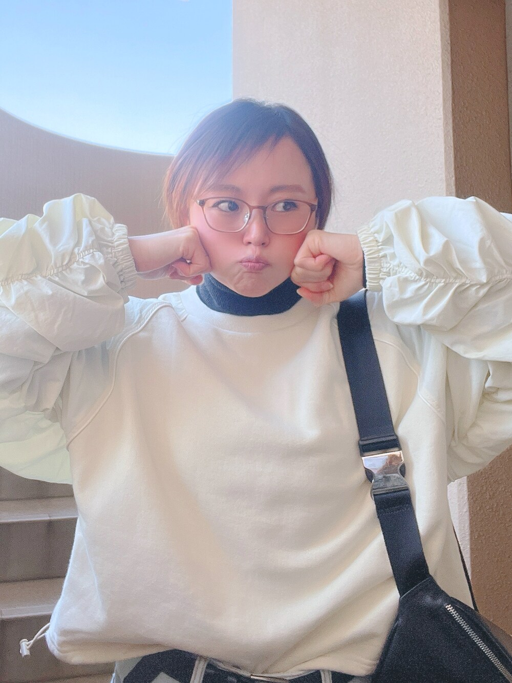 ホワイト系のスウェット、ブルー系のデニムパンツ、ベージュ系のスニーカーを着用したレディースの冬コーディネートの2枚目の写真