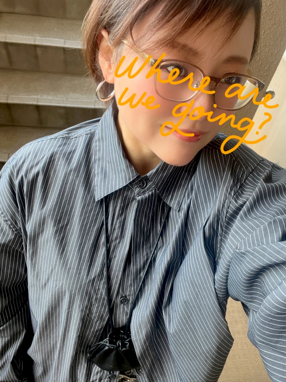 ブルー系のデニムパンツ、ブラウン系のショルダーバッグ、グレー系のシャツ/ブラウスを着用したレディースの春コーディネートの2枚目の写真