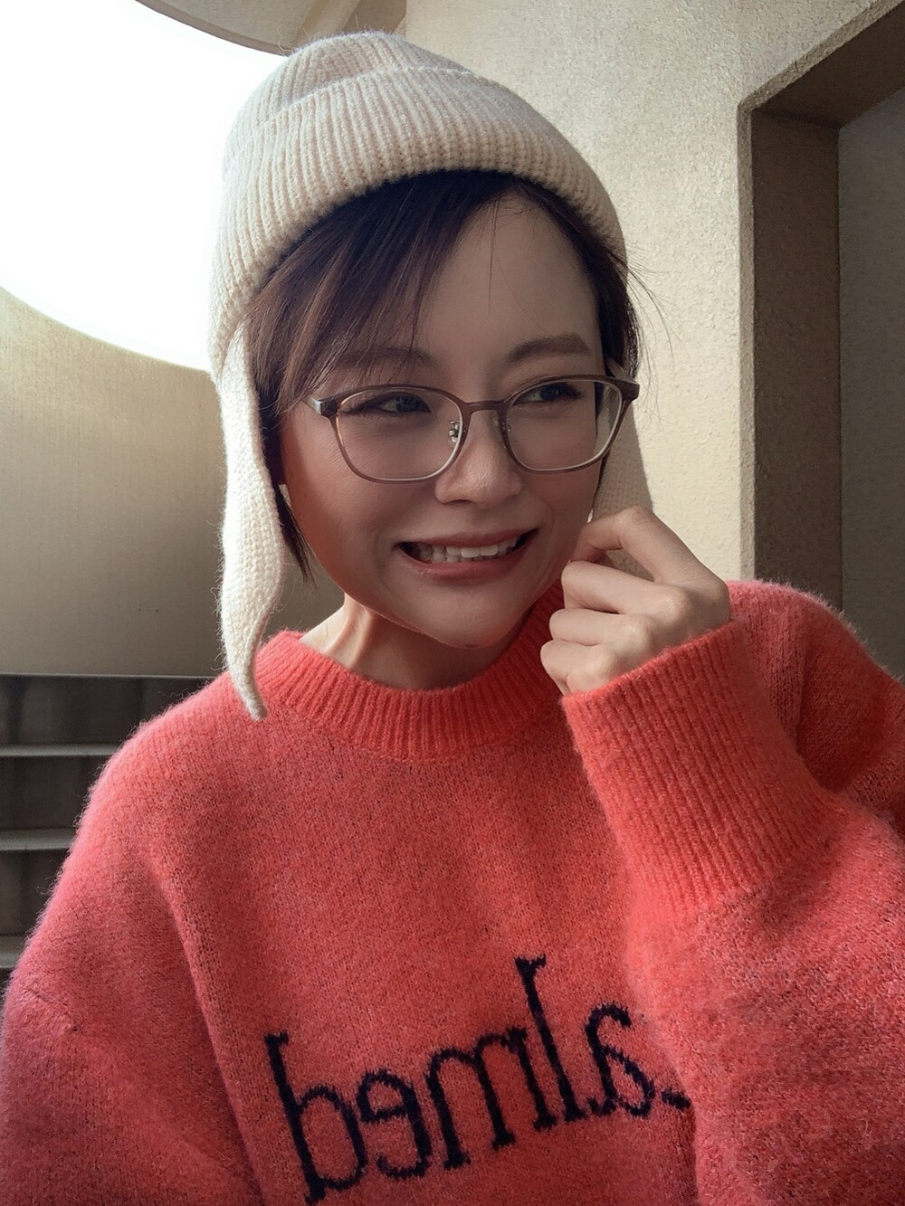 ホワイト系のダウンベスト、オレンジ系のニット/セーター、ホワイト系のその他パンツを着用したレディースの冬コーディネートの3枚目の写真