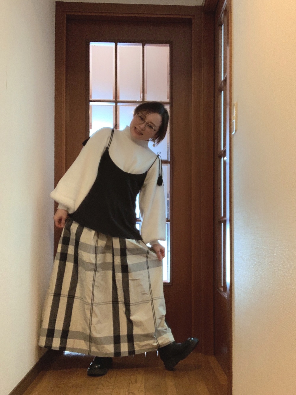 ブラック系のシャツ/ブラウス、ホワイト系のニット/セーター、ホワイト系のスカートを着用したレディースの春コーディネートの2枚目の写真