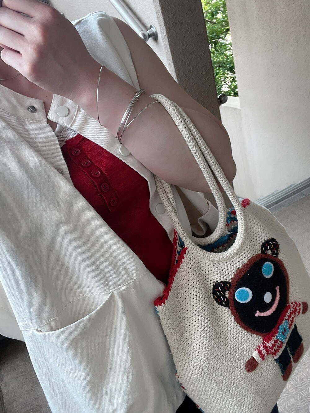 レッド系のタンクトップ、ホワイト系のベスト、ホワイト系のサンダルを着用したレディースの夏コーディネートの2枚目の写真