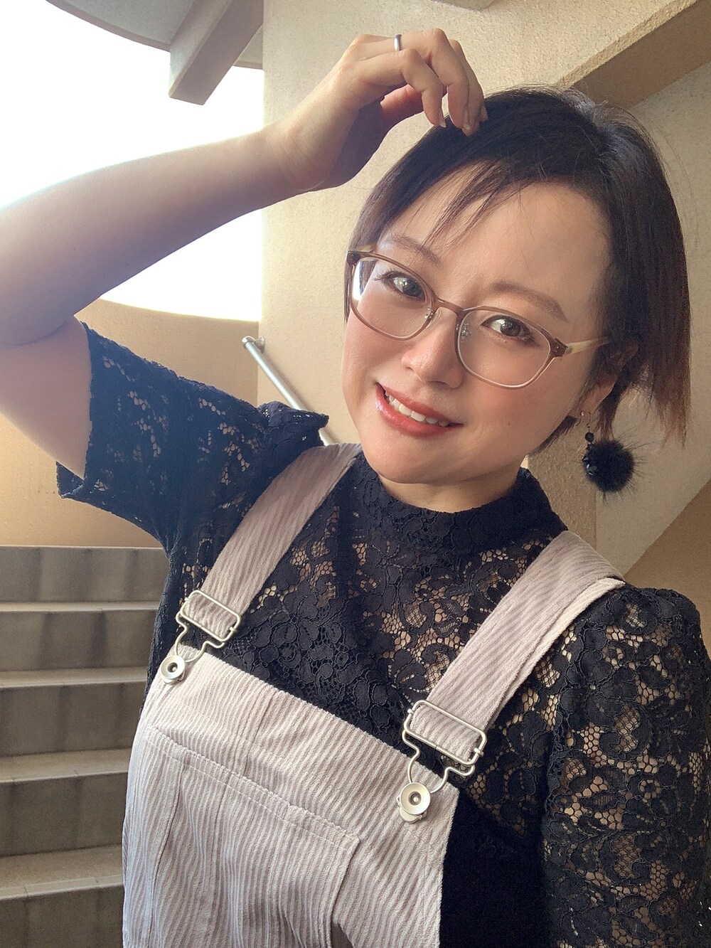 グレー系のジャンパースカート、ブラック系のシャツ/ブラウス、ブラック系のサンダルを着用したレディースの秋コーディネートの3枚目の写真