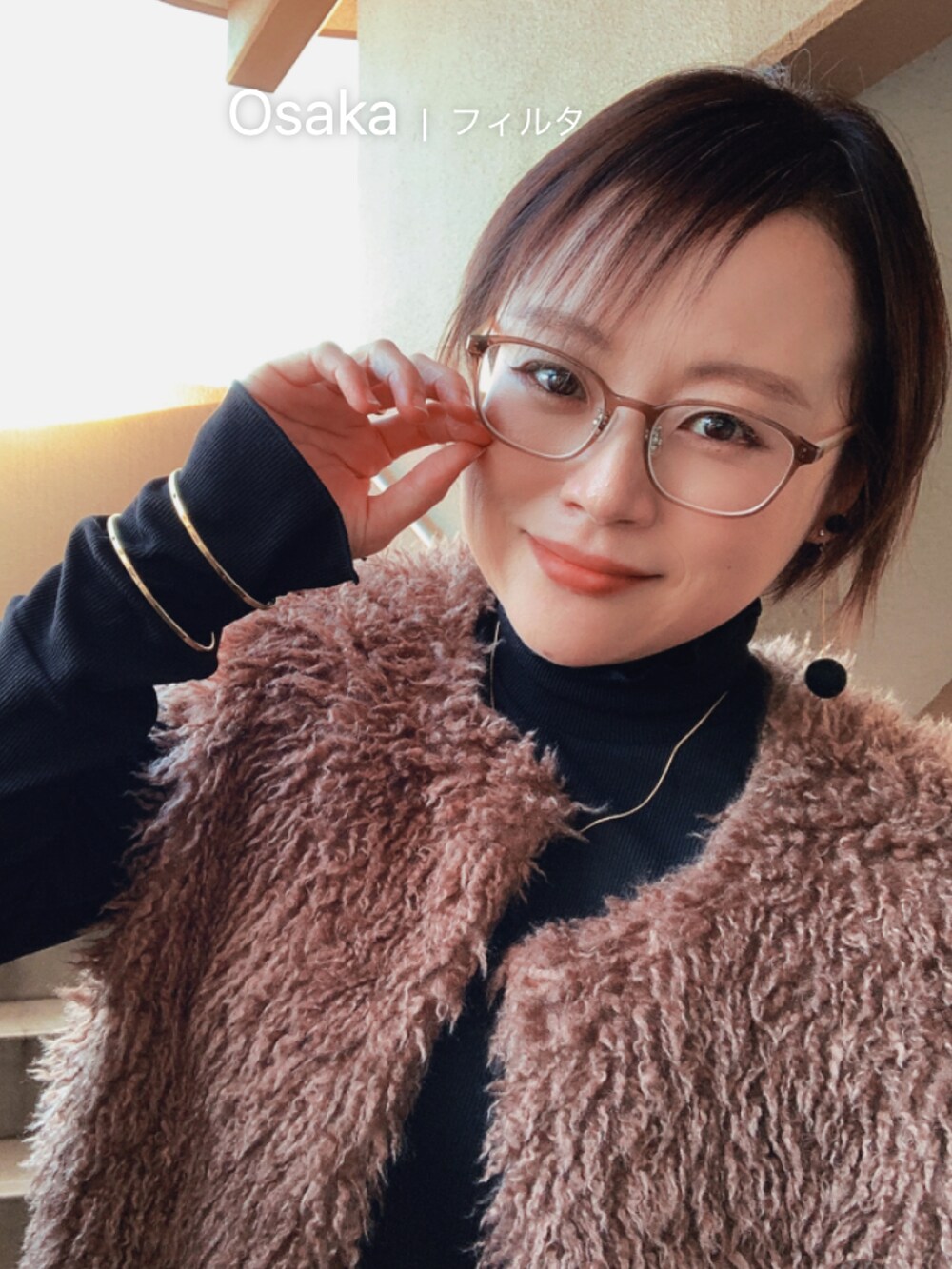 ブラック系のTシャツ/カットソー、ブラウン系のベスト、ブルー系のデニムパンツを着用したレディースの秋コーディネートの2枚目の写真