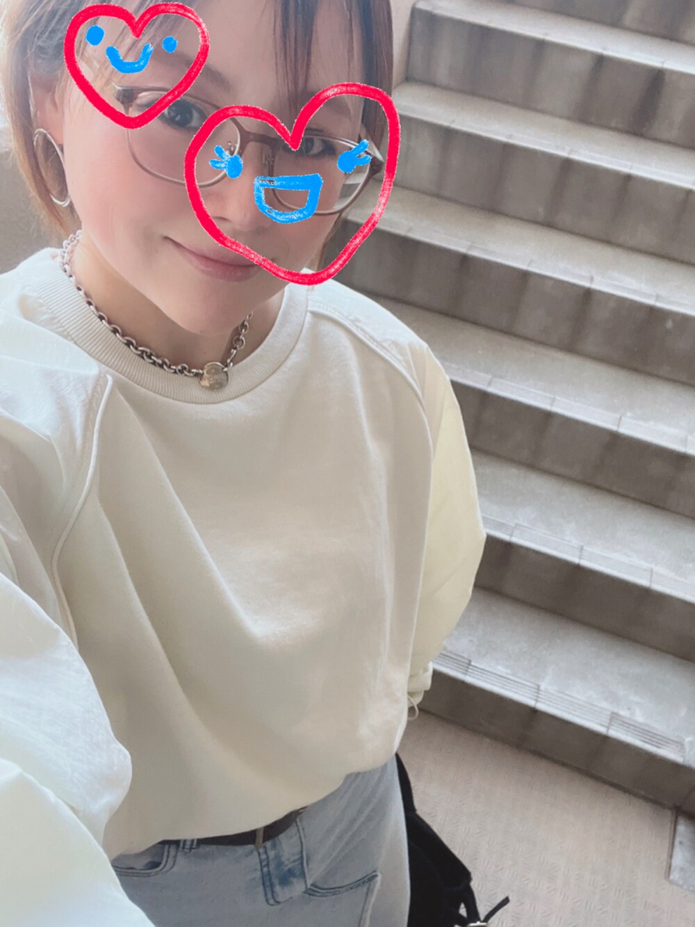 ホワイト系のスウェット、ブルー系のデニムスカート、ブラック系のスニーカーを着用したレディースの春コーディネートの2枚目の写真