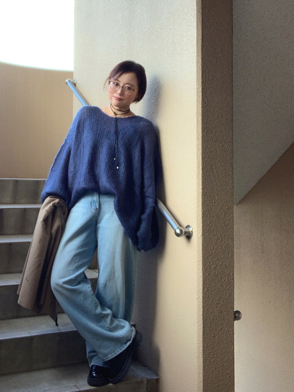 ブルー系のニット/セーター、ブルー系のデニムパンツ、ブラック系のブーツを着用したレディースの冬コーディネートの2枚目の写真