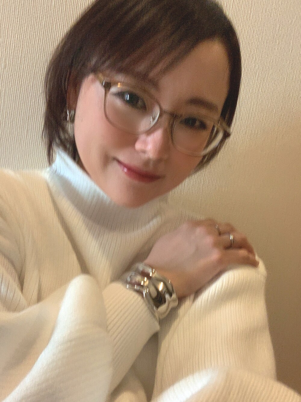 ホワイト系のニット/セーター、ブルー系のスラックス、ブラック系のブーツを着用したレディースの冬コーディネートの2枚目の写真