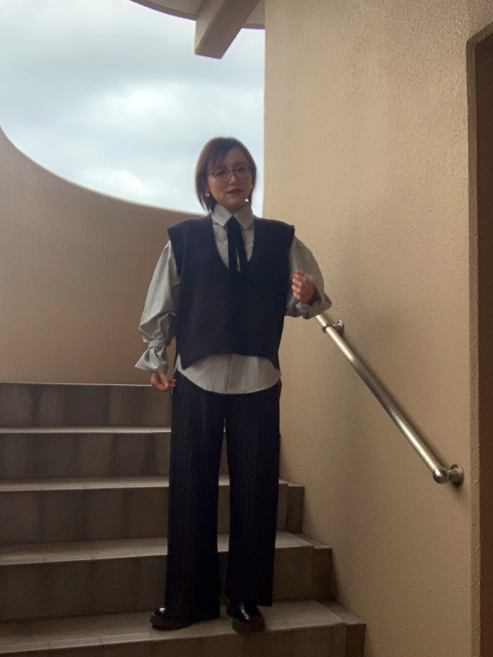 ブラック系のベスト、ブラック系のシャツ/ブラウス、ブラック系のその他パンツを着用したレディースの冬コーディネートの2枚目の写真