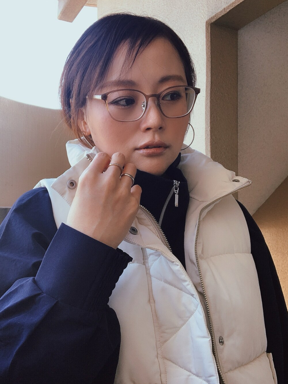 ホワイト系のダウンベスト、ブルー系のその他アウター、ブルー系のデニムパンツを着用したレディースの冬コーディネートの3枚目の写真