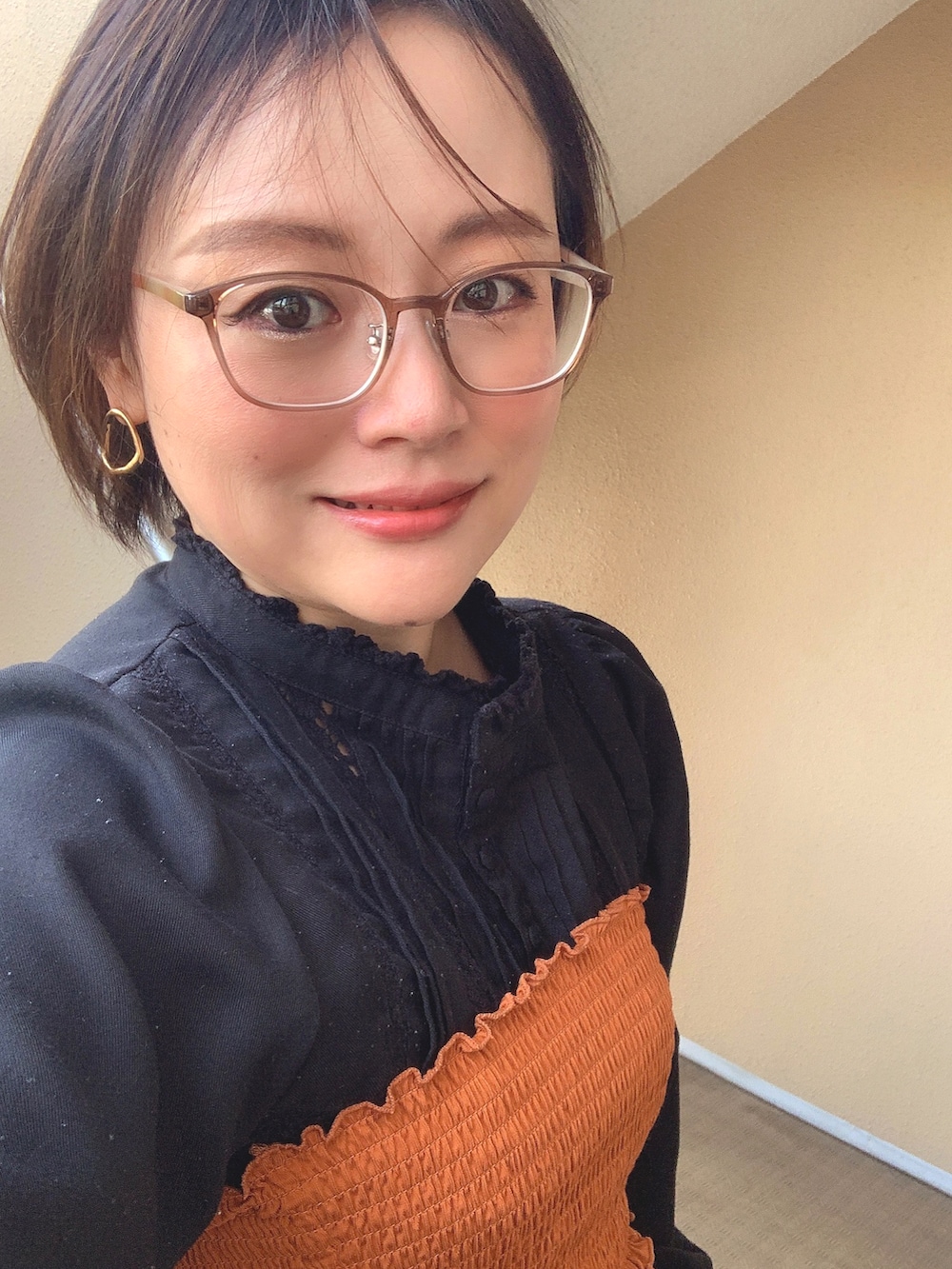ブラウン系のチューブトップ、ブルー系のデニムパンツ、ブラック系のサンダルを着用したレディースの春コーディネートの2枚目の写真