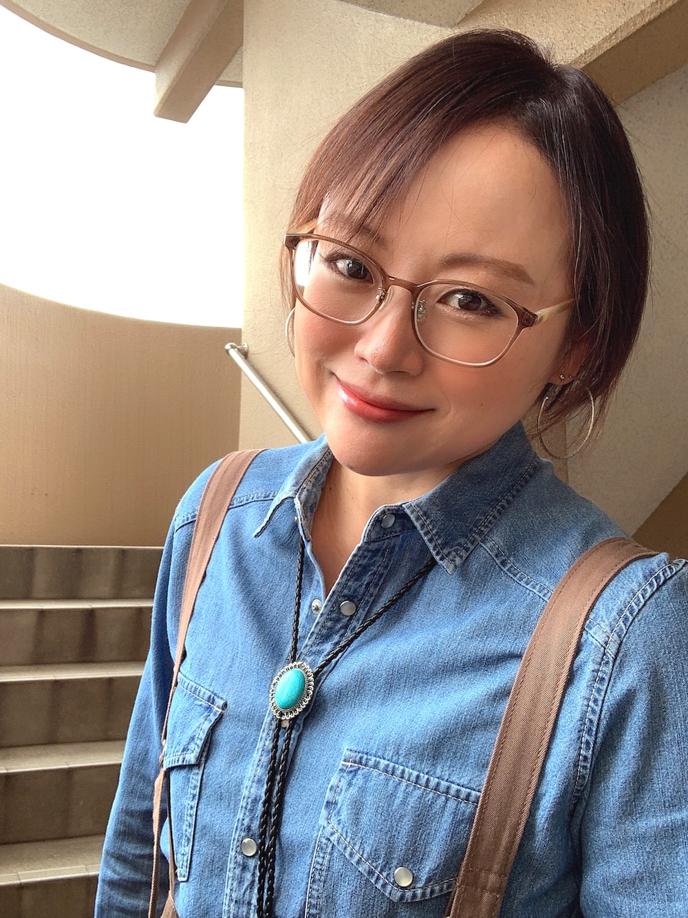 ブルー系のシャツ/ブラウス、ブラウン系のその他パンツ、ブラック系のブーツを着用したレディースの秋コーディネートの2枚目の写真