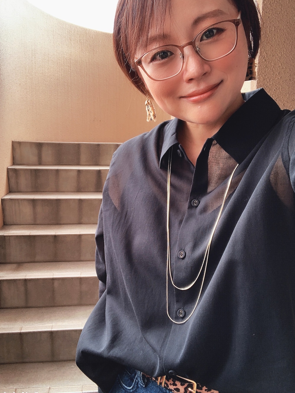 ブラック系のシャツ/ブラウス、ブラック系のニット/セーター、ブルー系のデニムパンツを着用したレディースの秋コーディネートの2枚目の写真