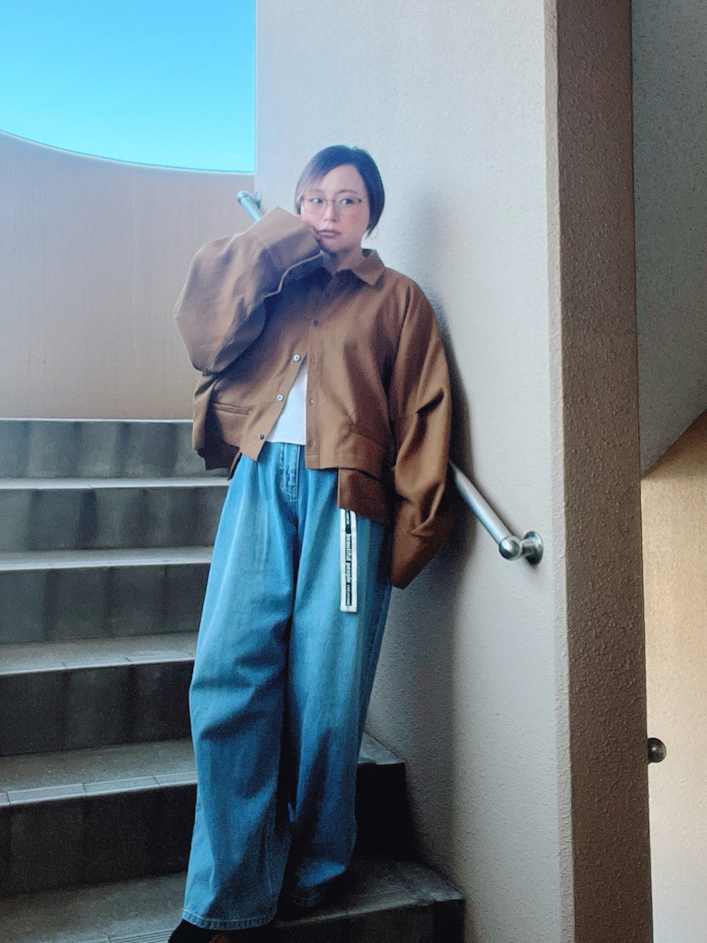 イエロー系のシャツ/ブラウス、ブルー系のデニムパンツ、ホワイト系のタンクトップを着用したレディースの秋コーディネートの2枚目の写真