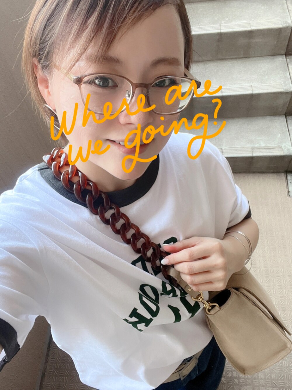 ホワイト系のTシャツ/カットソー、ブルー系のデニムパンツ、ベージュ系のショルダーバッグを着用したレディースの夏コーディネートの2枚目の写真