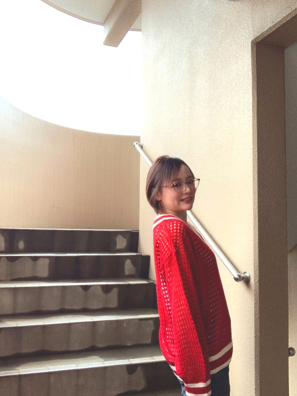 レッド系のニット/セーター、ホワイト系のタンクトップ、ブラック系のデニムパンツを着用したレディースの春コーディネートの3枚目の写真