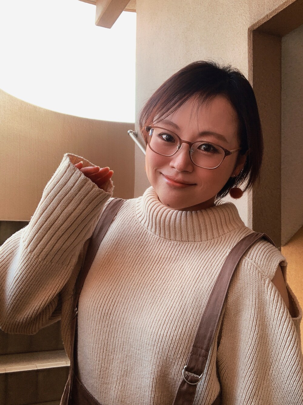 ホワイト系のニット/セーター、ブラウン系のその他パンツ、ベージュ系のスニーカーを着用したレディースの冬コーディネートの2枚目の写真