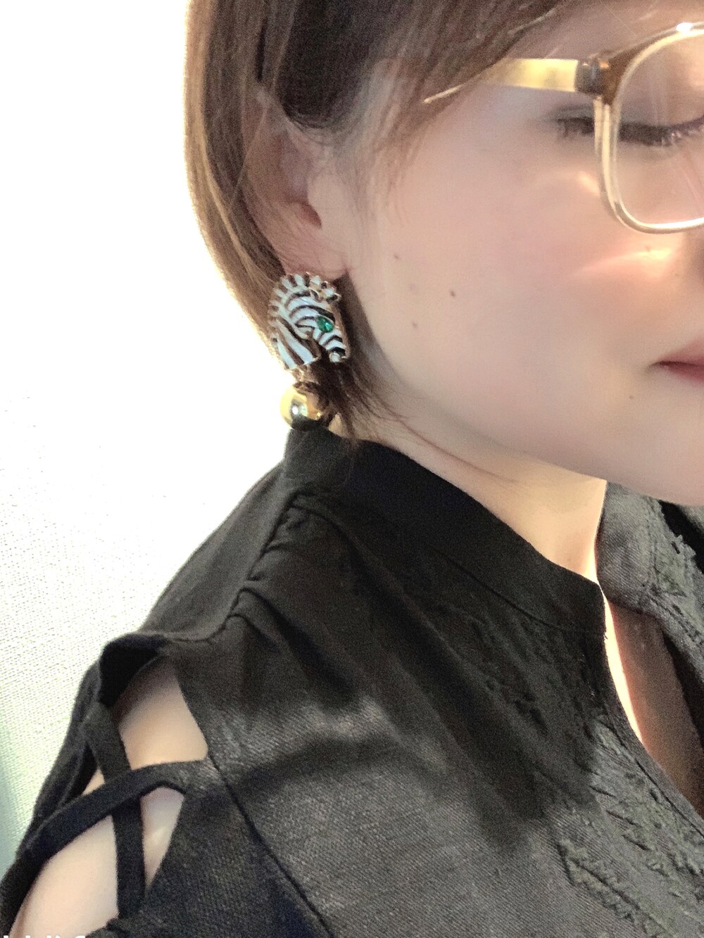 ブラック系のシャツ/ブラウス、グリーン系のサンダル、ブルー系のデニムパンツを着用したレディースの秋コーディネートの2枚目の写真