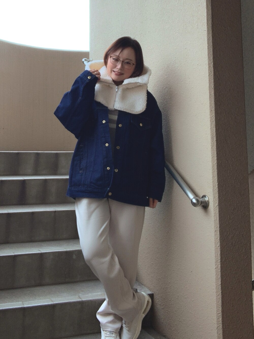 ブルー系のデニムジャケット、グレー系のニット/セーター、ホワイト系のその他パンツを着用したレディースの冬コーディネートの2枚目の写真