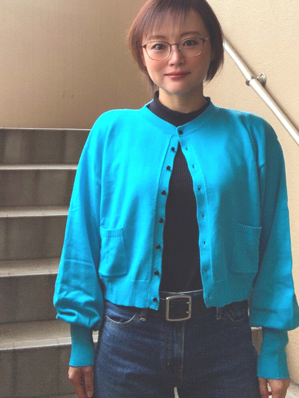 ブルー系のカーディガン/ボレロ、ブラック系のTシャツ/カットソー、ブルー系のデニムパンツを着用したレディースの冬コーディネートの2枚目の写真