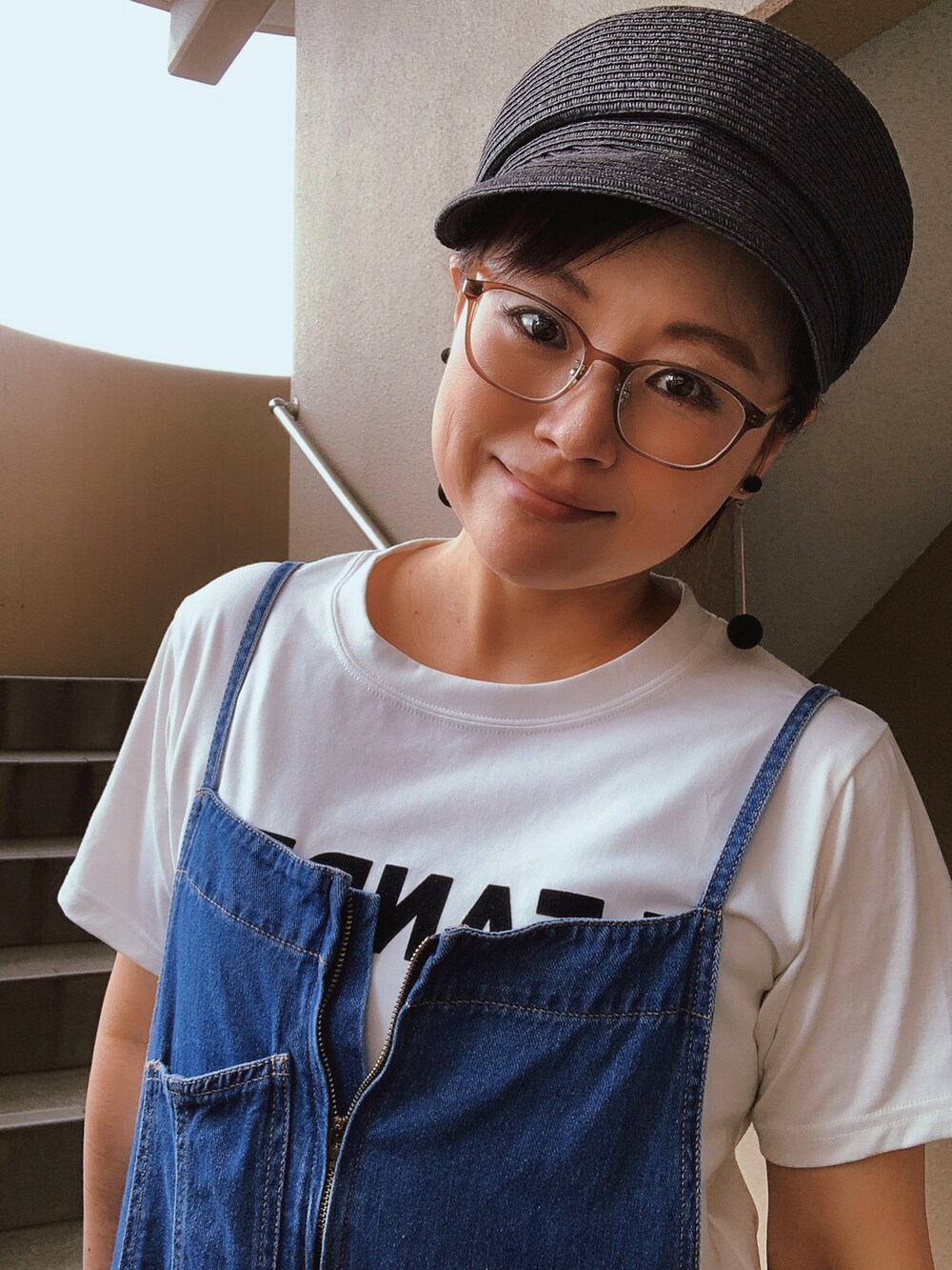 ホワイト系のTシャツ/カットソー、ブルー系のサロペット/オーバーオール、ブラック系のサンダルを着用したレディースの秋コーディネートの2枚目の写真