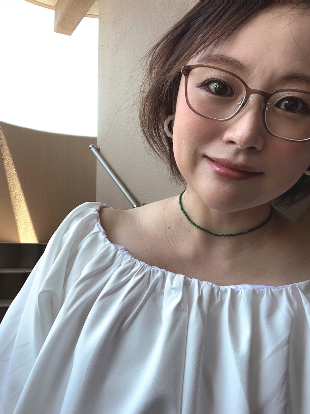 ホワイト系のシャツ/ブラウス、グリーン系のスカート、ホワイト系のサンダルを着用したレディースの夏コーディネートの2枚目の写真