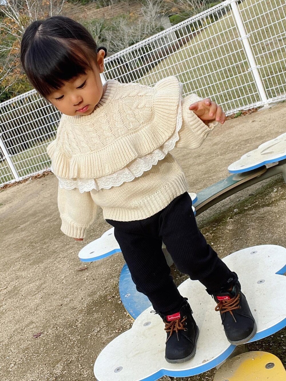 ホワイト系のニット/セーター、ブラック系のパンツ、ブラック系のシューズを着用したキッズの秋コーディネートの2枚目の写真