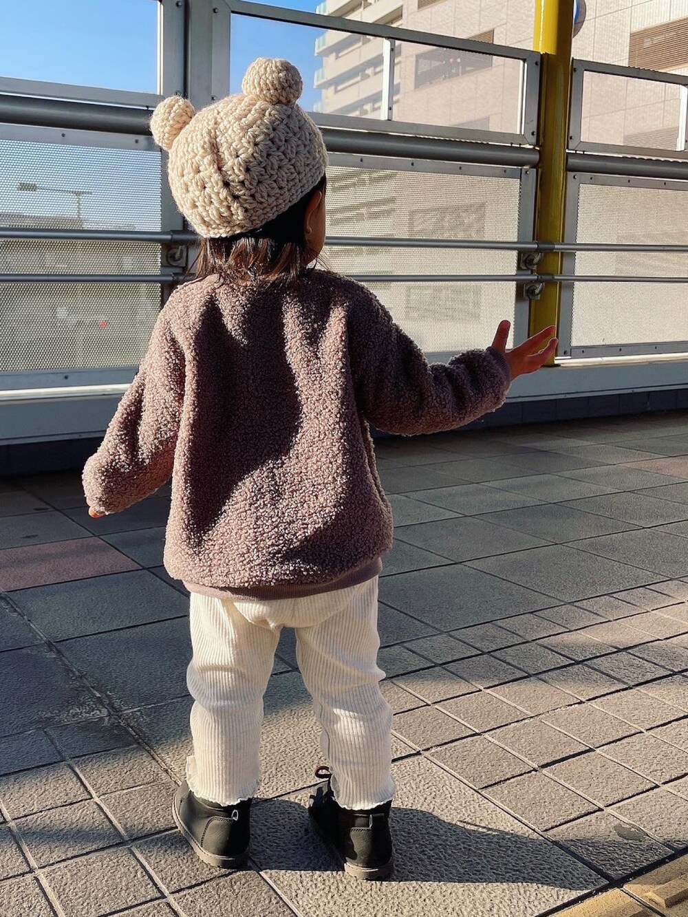 ブラウン系のトップス、ホワイト系のパンツ、ブラック系のシューズを着用したキッズの秋コーディネートの2枚目の写真