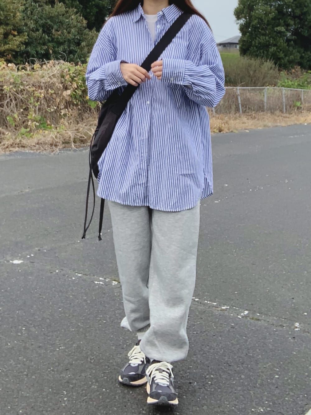 ブルー系のシャツ/ブラウス、グレー系のスウェットパンツ、ブルー系のスニーカーを着用したレディースの秋コーディネートの4枚目の写真