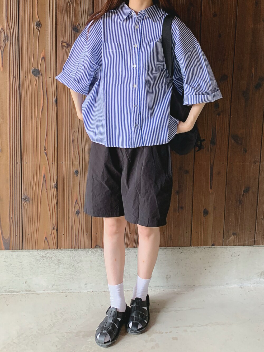 ブルー系のシャツ/ブラウス、ブラック系のサンダルを着用したレディースの夏コーディネートの2枚目の写真