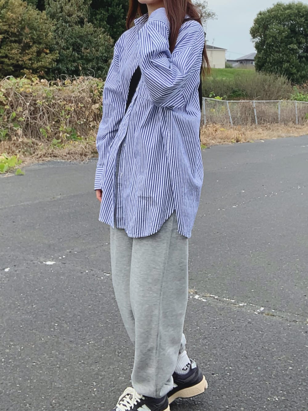 ブルー系のシャツ/ブラウス、グレー系のスウェットパンツ、ブルー系のスニーカーを着用したレディースの秋コーディネートの3枚目の写真