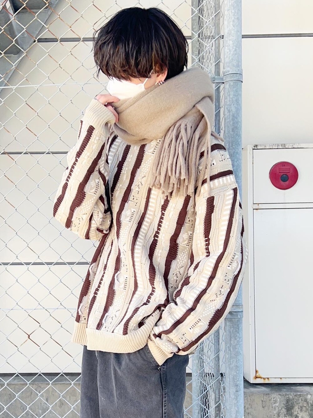 ベージュ系のニット/セーター、ベージュ系のマフラーを着用したメンズの冬コーディネートの2枚目の写真