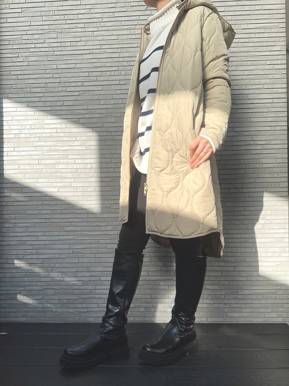 ベージュ系のその他アウター、ブラック系のブーツ、ブラック系のトップスを着用したレディースの冬コーディネートの2枚目の写真