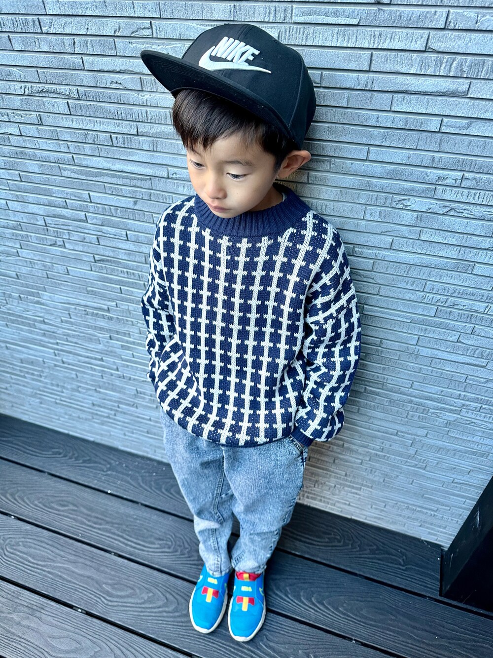 ベージュ系のダウンジャケット/コート、ブルー系のニット/セーター、その他のデニムパンツを着用したキッズの冬コーディネートの4枚目の写真