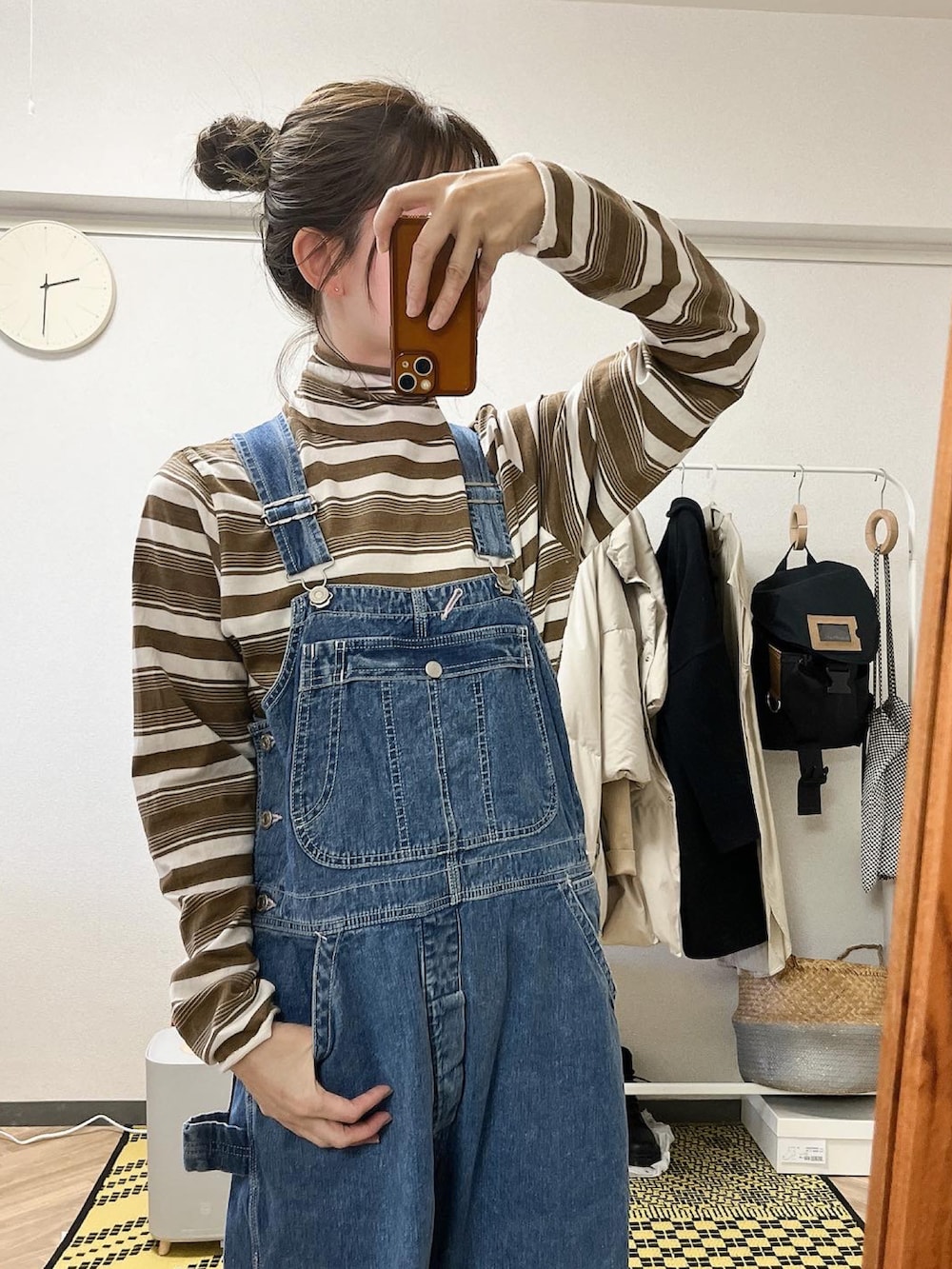 ブルー系のサロペット/オーバーオール、ブラウン系のTシャツ/カットソー、ベージュ系のニット/セーターを着用したレディースの冬コーディネートの2枚目の写真