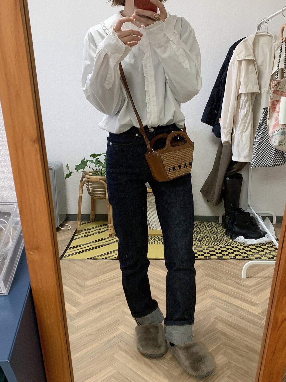 ブラウン系のショルダーバッグ、ホワイト系のシャツ/ブラウス、ブルー系のデニムパンツを着用したレディースの春コーディネートの2枚目の写真