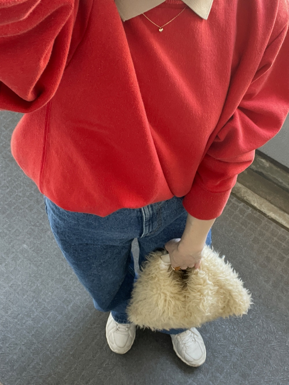 ブルー系のデニムパンツ、ベージュ系のトートバッグ、レッド系のスウェットを着用したレディースの秋コーディネートの2枚目の写真