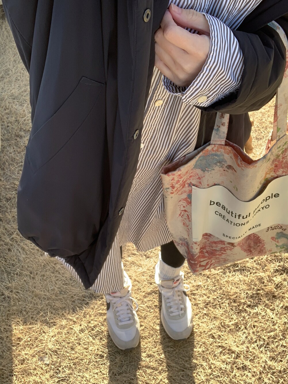 ブラック系のシャツ/ブラウス、ブラック系のダウンジャケット/コート、その他のトートバッグを着用したレディースの春コーディネートの2枚目の写真