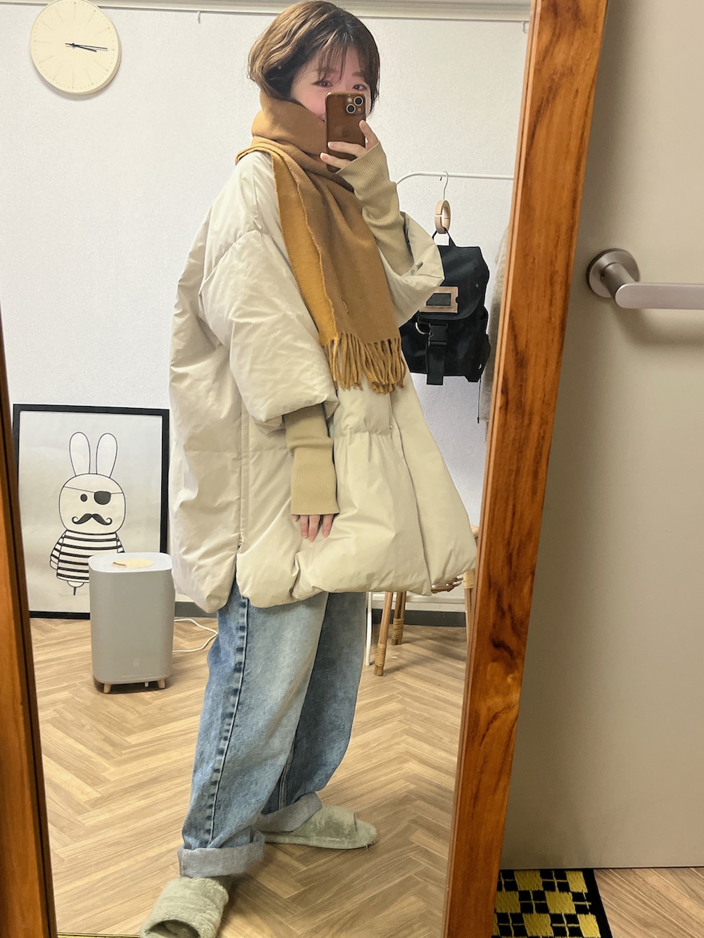 ベージュ系のダウンジャケット/コート、ブルー系のデニムパンツ、ブラウン系のマフラーを着用したレディースの秋コーディネートの2枚目の写真