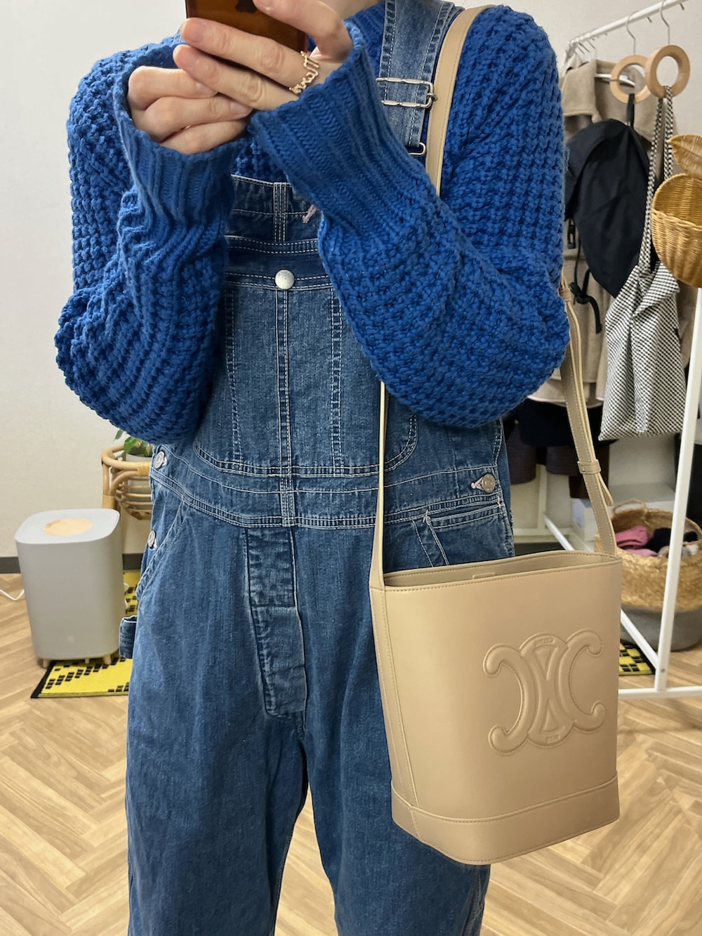 ベージュ系のショルダーバッグ、ブラウン系のその他アウター、ブルー系のニット/セーターを着用したレディースの冬コーディネートの2枚目の写真