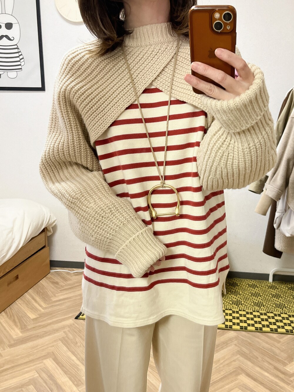 ベージュ系のニット/セーター、レッド系のTシャツ/カットソー、ブラウン系のその他アウターを着用したレディースの冬コーディネートの2枚目の写真