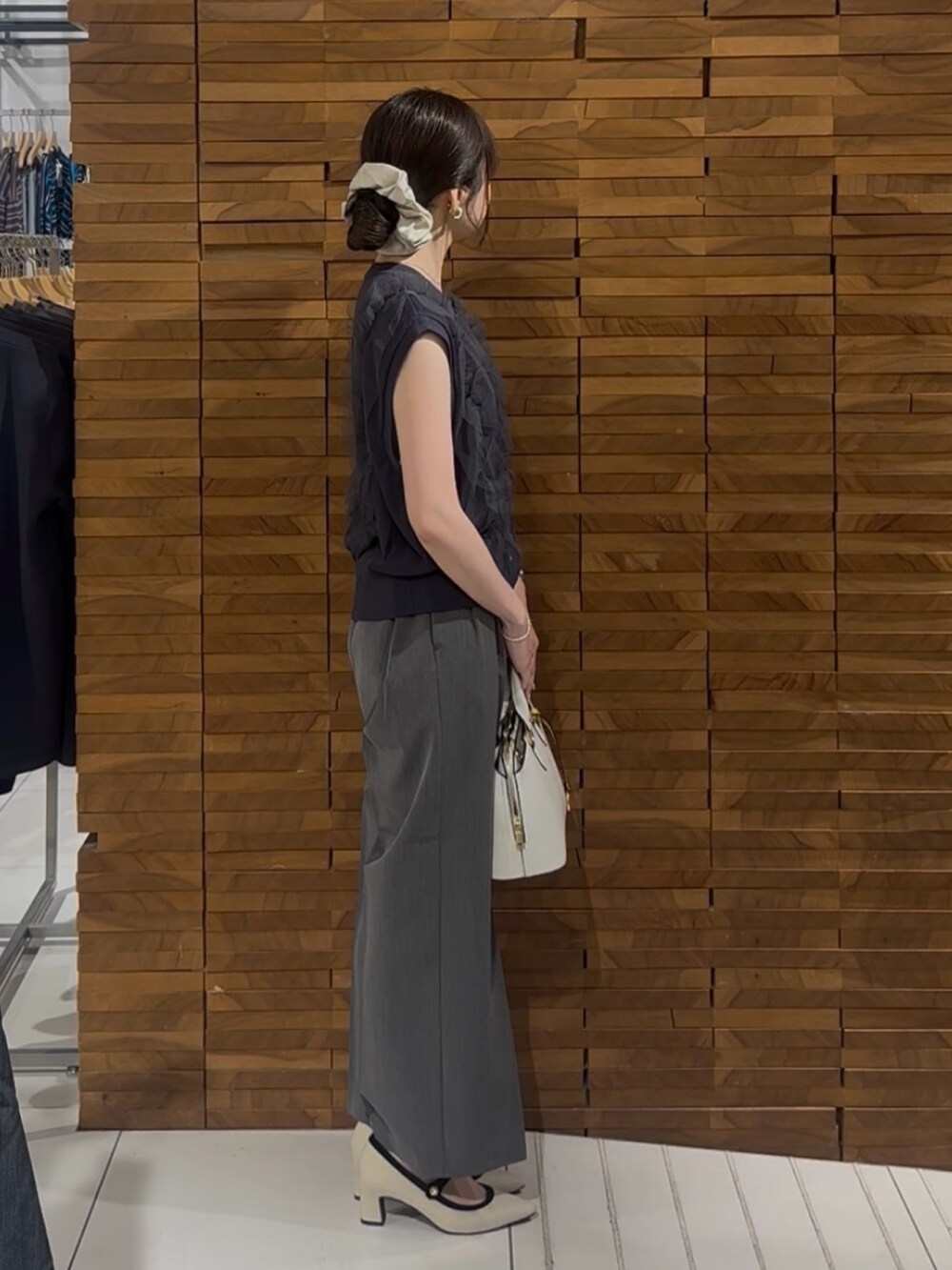 グレー系のベスト、グレー系のその他パンツ、ホワイト系のハンドバッグを着用したレディースの春コーディネートの2枚目の写真