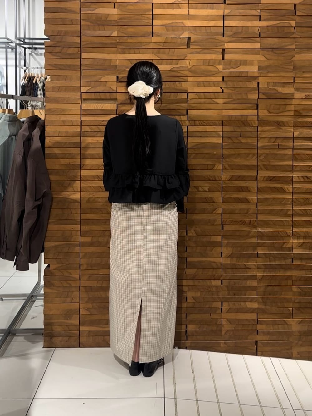 ブラック系のシャツ/ブラウス、ホワイト系のスカート、ブラック系のパンプスを着用したレディースの春コーディネートの3枚目の写真